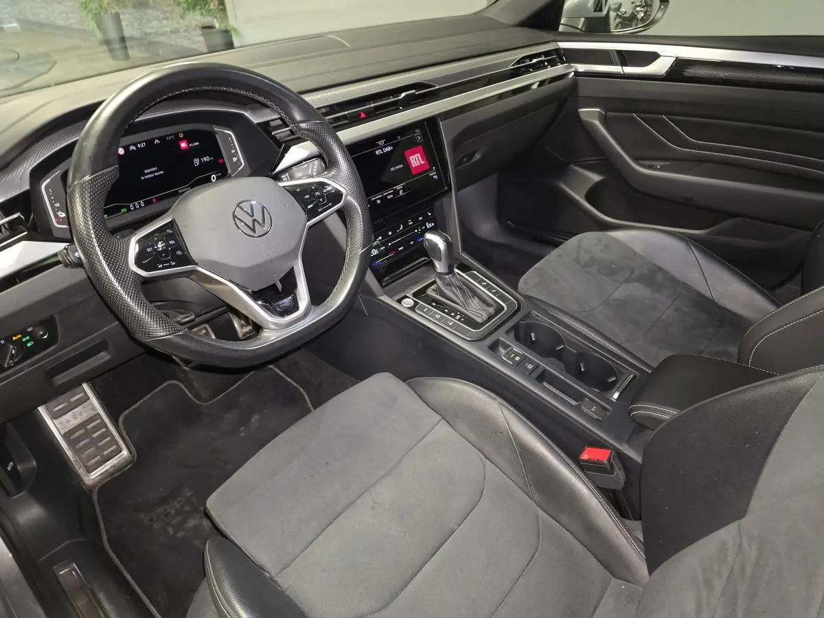 Vue intérieure côté conducteur du Volkswagen Arteon Shooting Brake gris, avec volant multifonction, écran tactile et sellerie mixte cuir/alcantara.