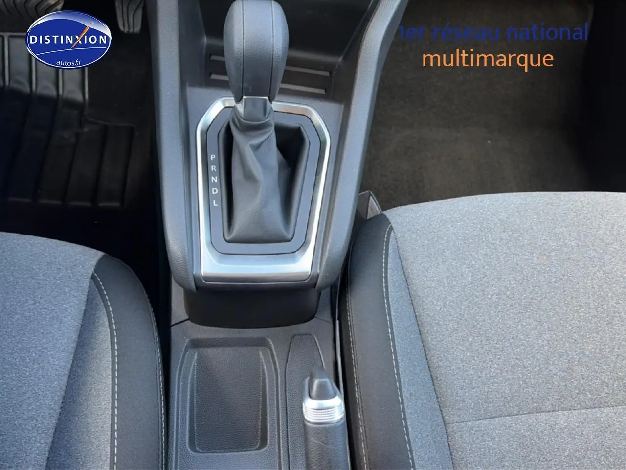 Vue rapprochée de la console centrale et levier de vitesse automatique d'une Renault Clio V gris métal, sièges tissu gris.