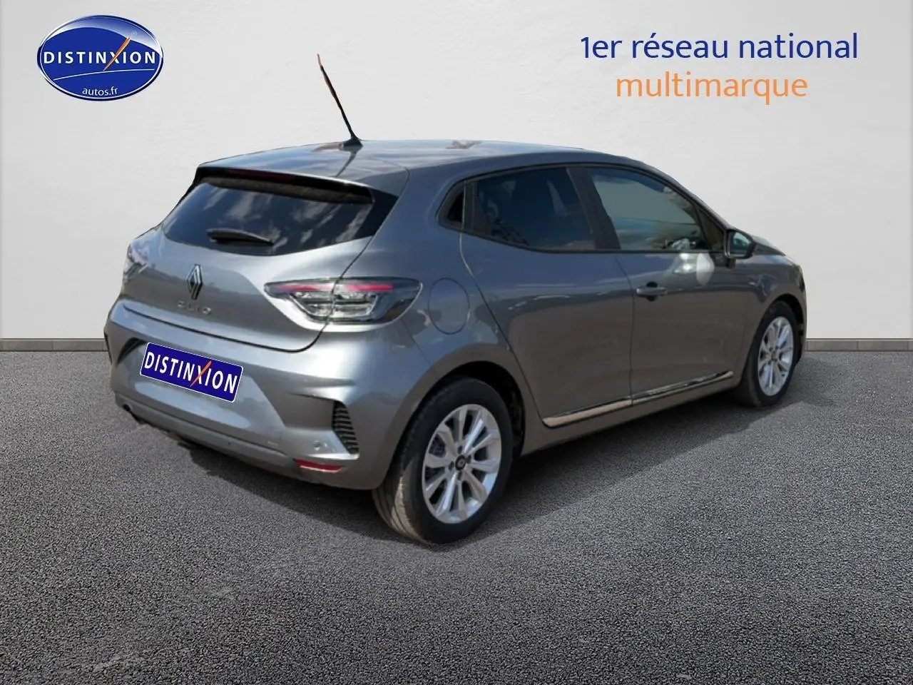 Vue 3/4 arrière droite d'une Renault Clio V gris métal avec becquet et feux arrière LED visibles.