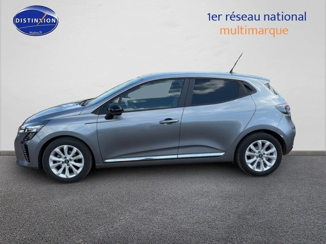 Profil côté gauche de la Renault Clio V gris métal 2025 avec jantes alliage et rétroviseurs noirs.