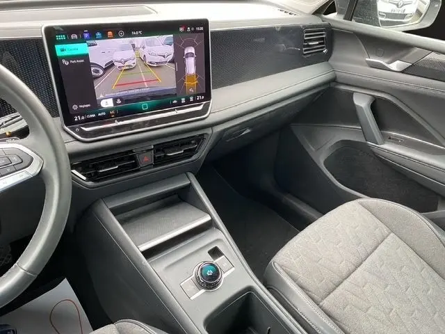 Vue intérieure côté passager du Volkswagen Tiguan noir 2024, avec écran tactile central affichant la caméra de recul.