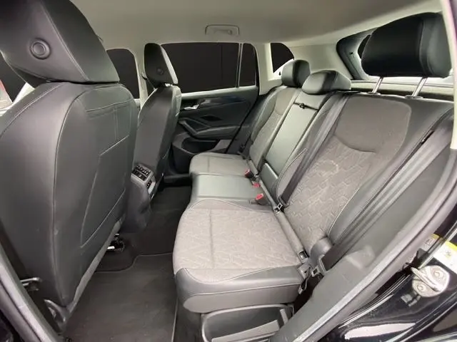 Vue intérieure arrière côté droit du Volkswagen Tiguan 2024 noir, sièges tissu gris avec ceintures de sécurité.