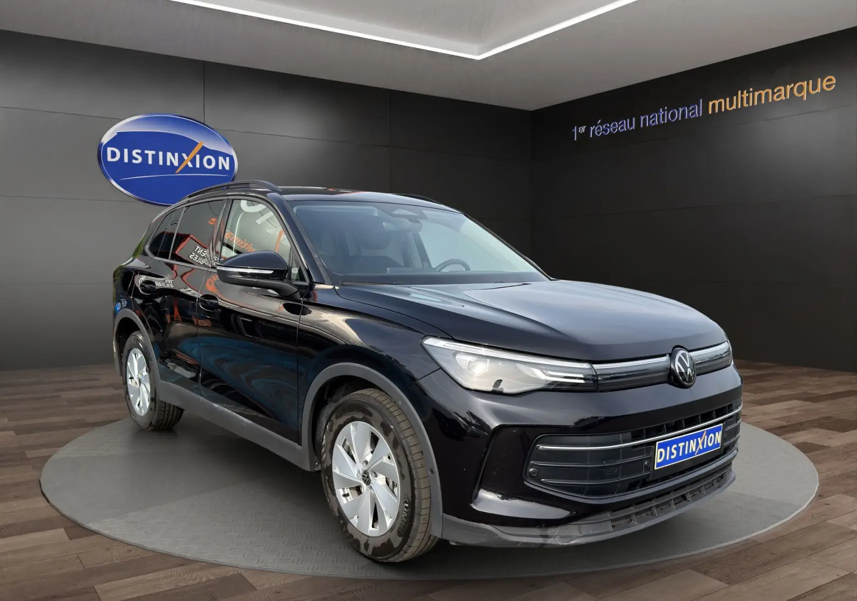 Volkswagen Tiguan noir 2024 en 3/4 avant droit, avec calandre épurée et jantes argentées visibles.
