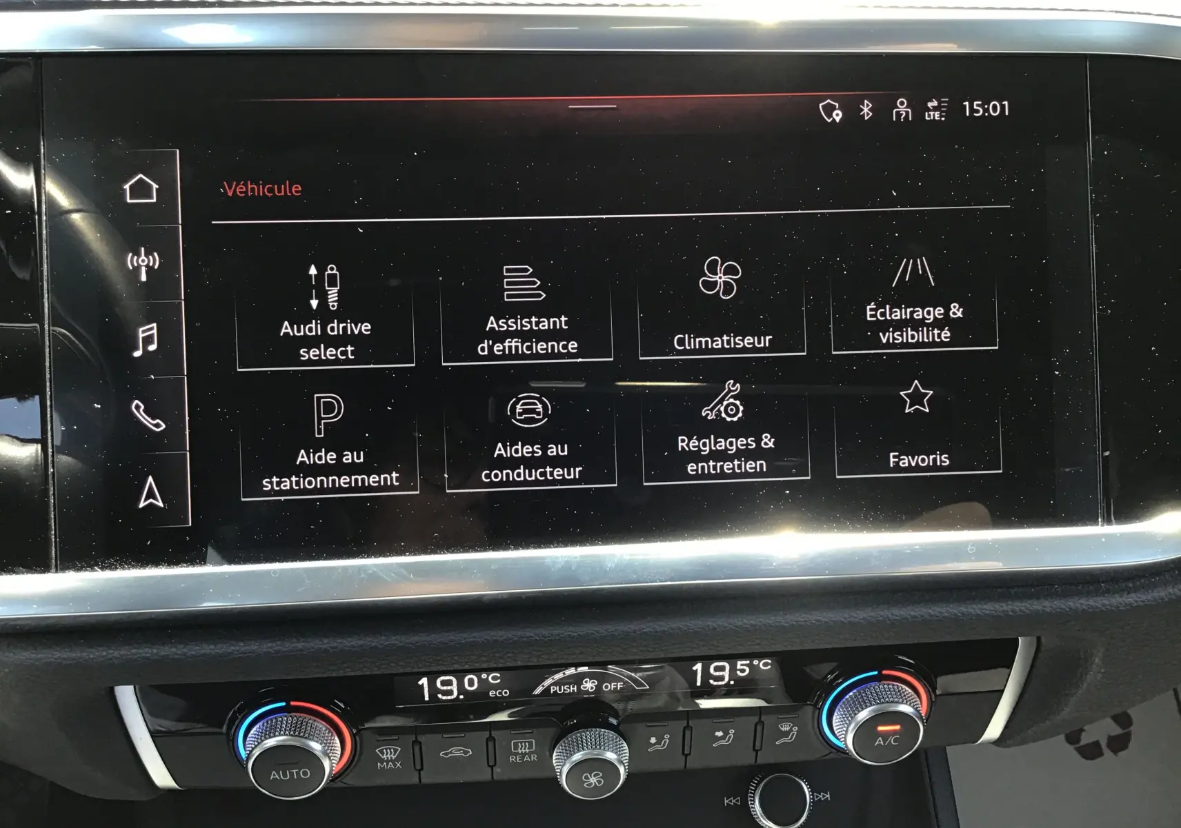 Vue rapprochée de l’écran tactile central et de la console de climatisation d’un Audi Q3 Sportback gris clair métal 2024.