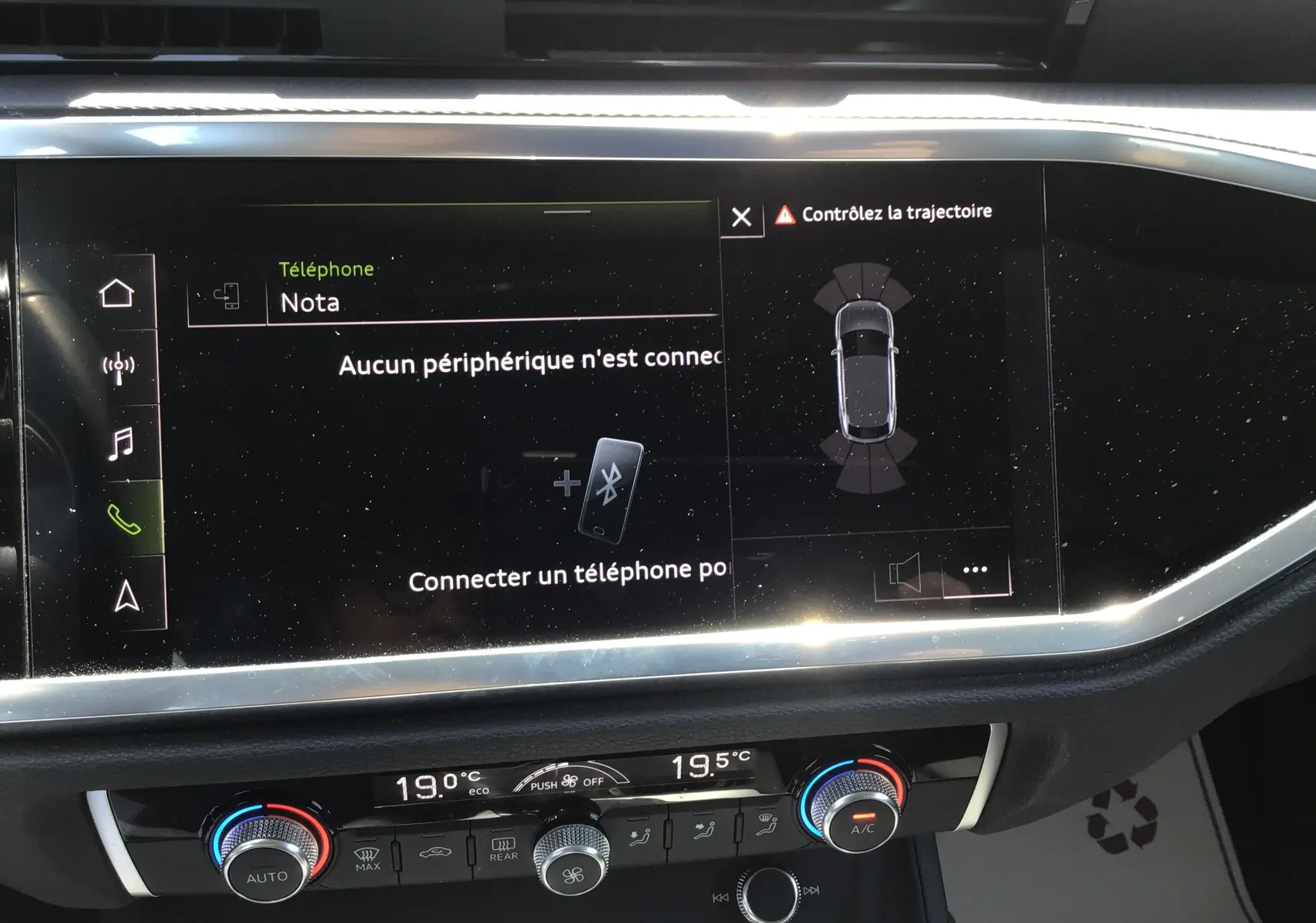 Vue rapprochée de l’écran tactile central et de la console de climatisation du tableau de bord de l’Audi Q3 Sportback gris clair 2024.