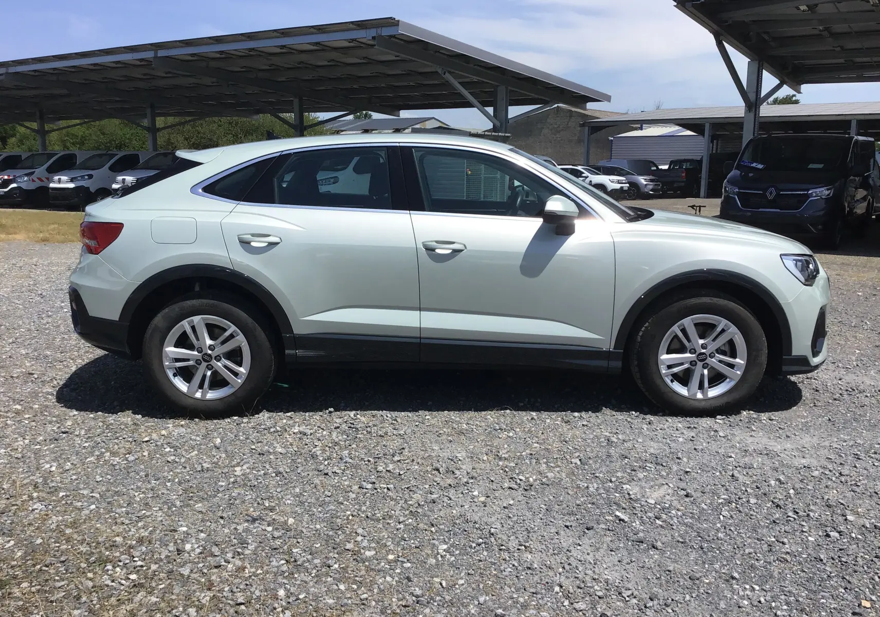 Audi Q3 Sportback gris clair métal en vue profil côté gauche, soulignant sa silhouette coupé SUV élégante.