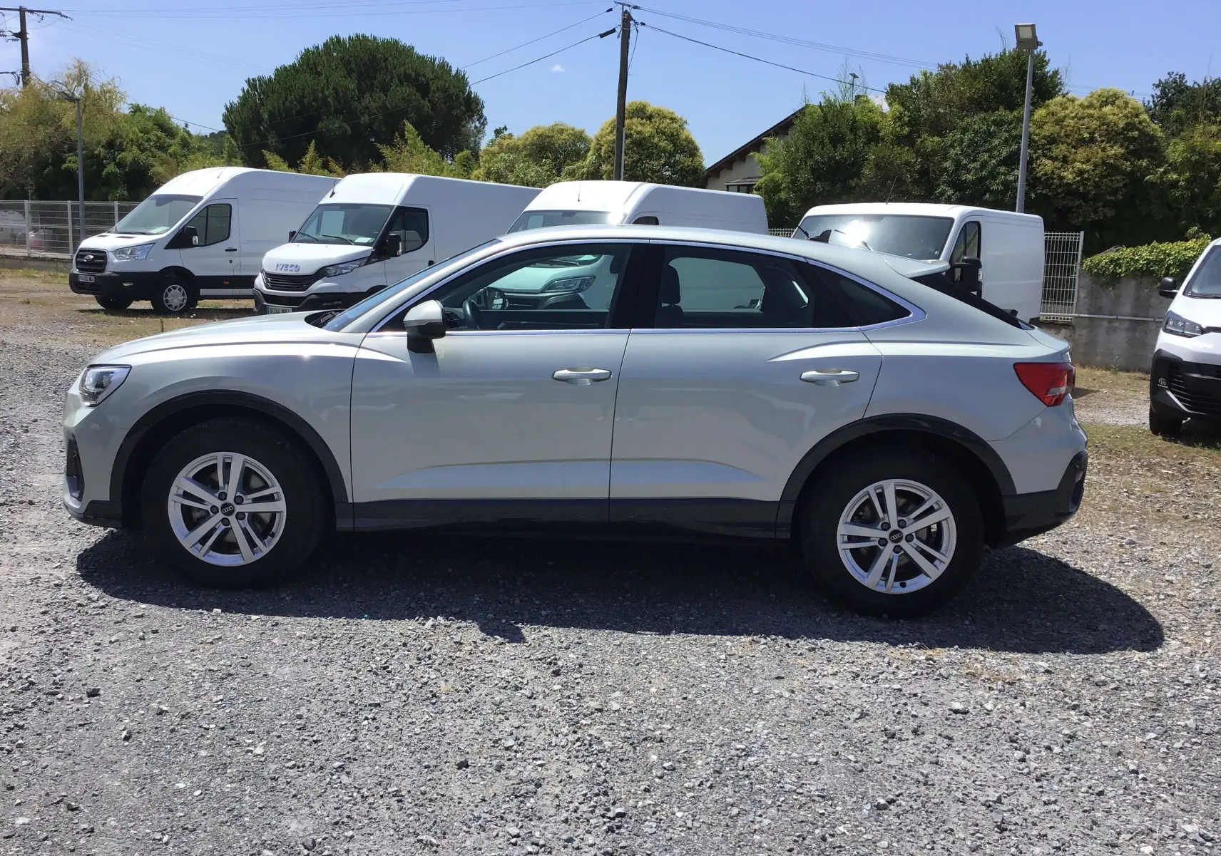 Audi Q3 Sportback gris clair métal, vue de profil côté gauche, soulignant la silhouette coupé et les jantes 17 pouces.