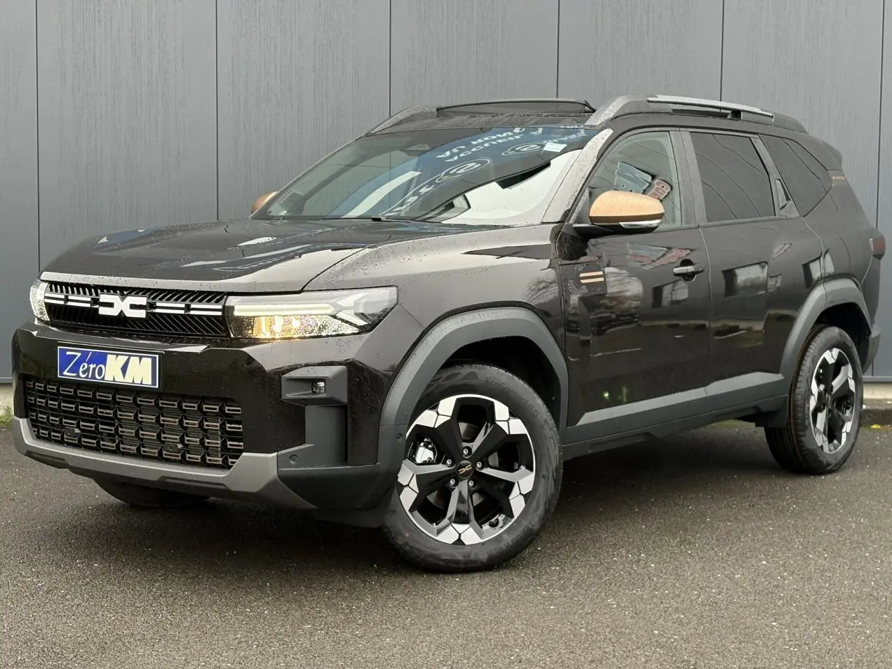 Vue 3/4 avant du Dacia Bigster noir nacré avec jantes diamantées noires et rétroviseurs couleur cuivre.