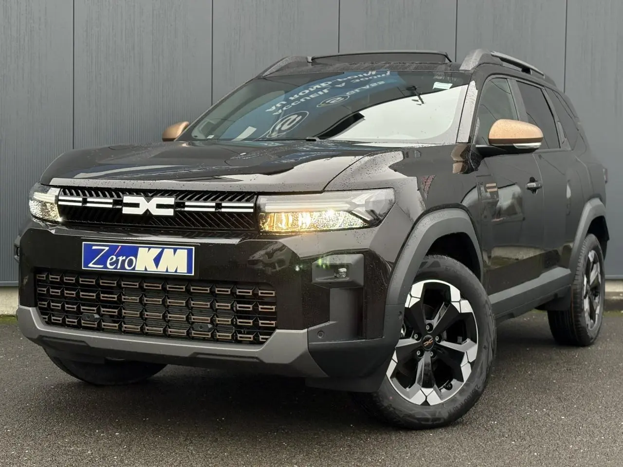 Vue 3/4 avant du Dacia Bigster noir nacré avec jantes diamantées et rétroviseurs couleur cuivre.