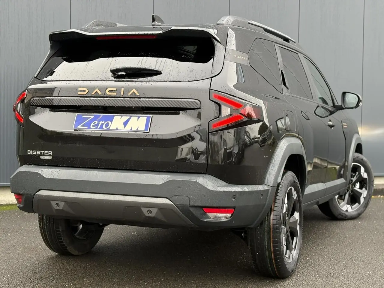 Vue 3/4 arrière droite du Dacia Bigster noir nacré avec hayon électrique et jantes alliage noires diamantées.
