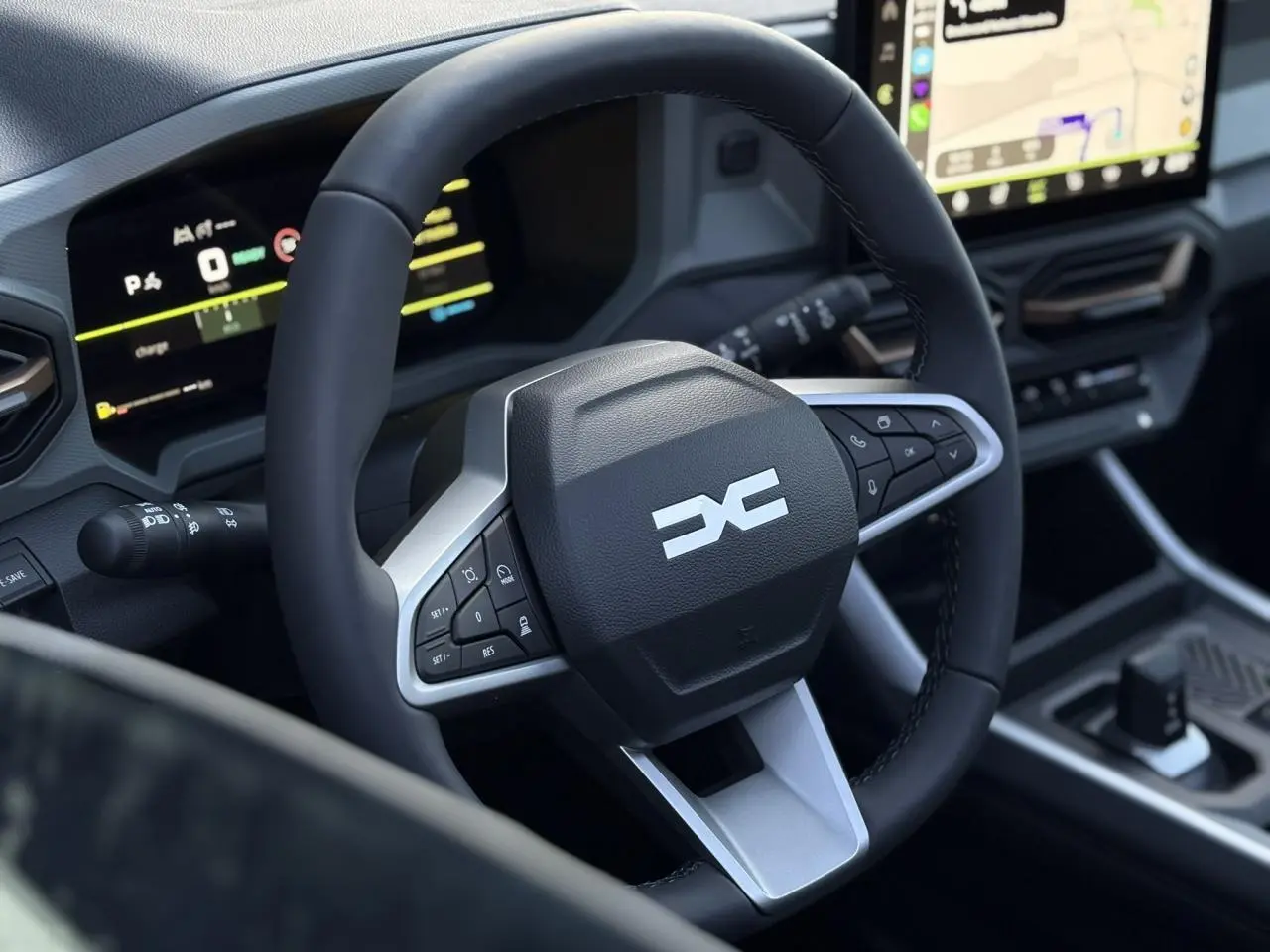 Gros plan sur le volant noir et argenté du Dacia Bigster 2026 avec tableau de bord numérique et écran tactile visible.