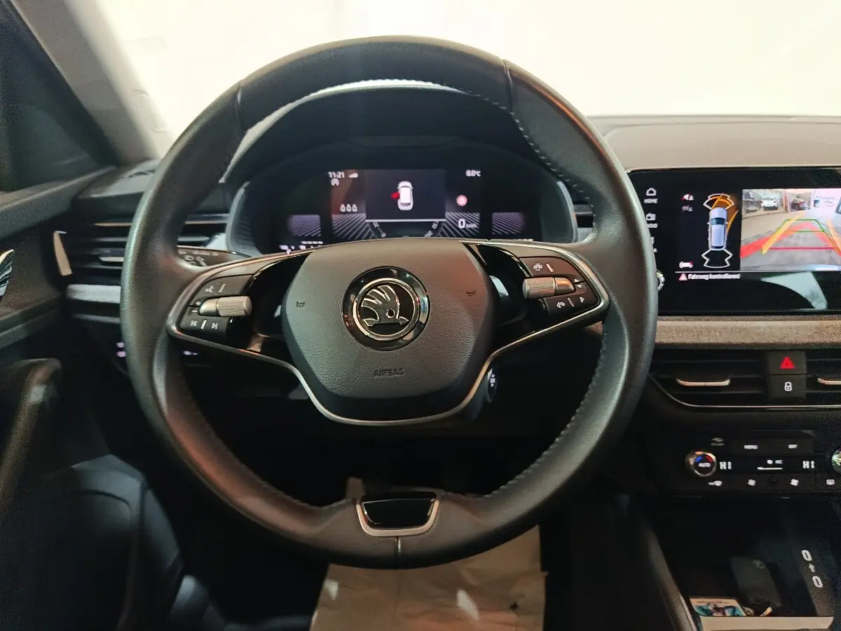 Vue frontale du volant cuir multifonctions noir et des écrans digitaux du tableau de bord du Skoda Kamiq gris clair 2024.