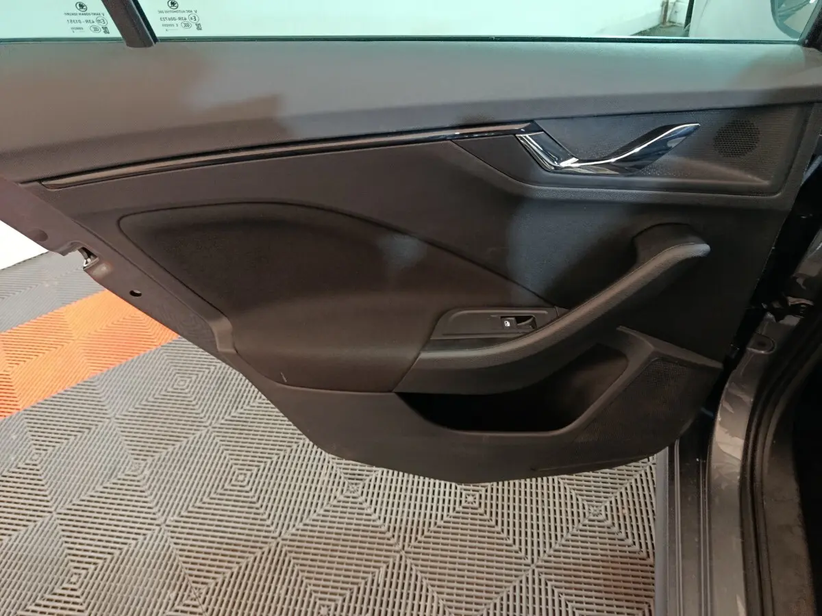 Vue rapprochée de la porte arrière droite noire du Skoda Kamiq 2024 avec poignée et commande de lève-vitre intégrée.