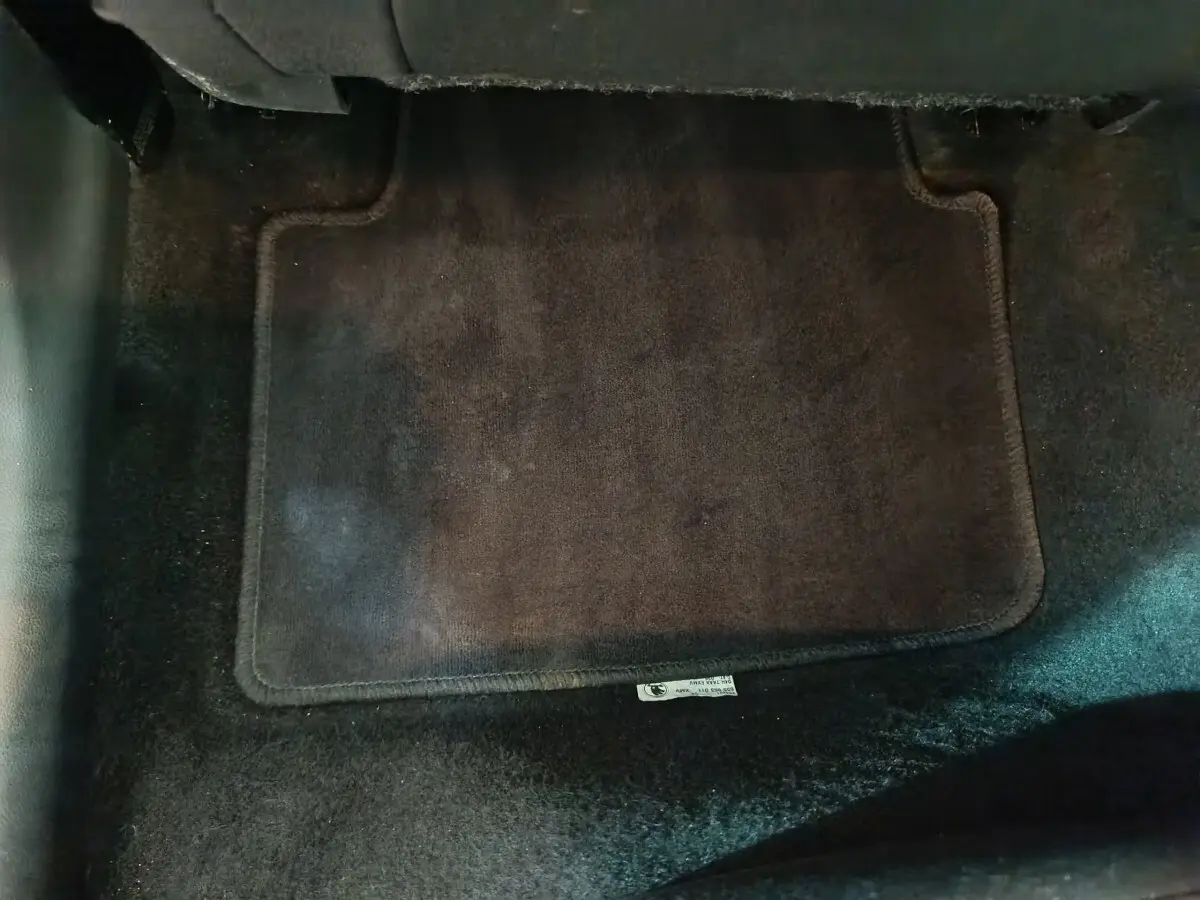Vue rapprochée du tapis de sol noir à l'avant d'un Skoda Kamiq gris clair, version 2024 essence.