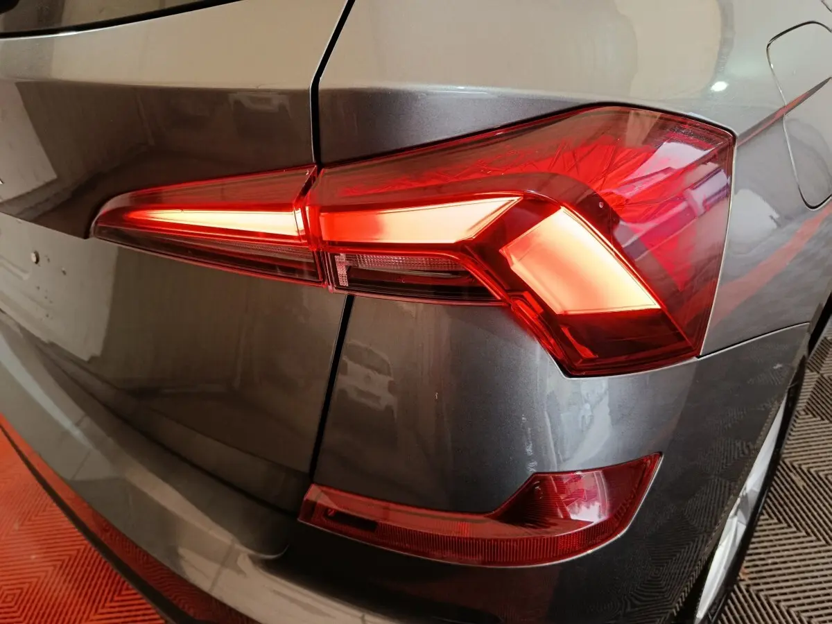 Gros plan sur le feu arrière droit d’un Skoda Kamiq gris clair, mettant en valeur son design LED angulaire.