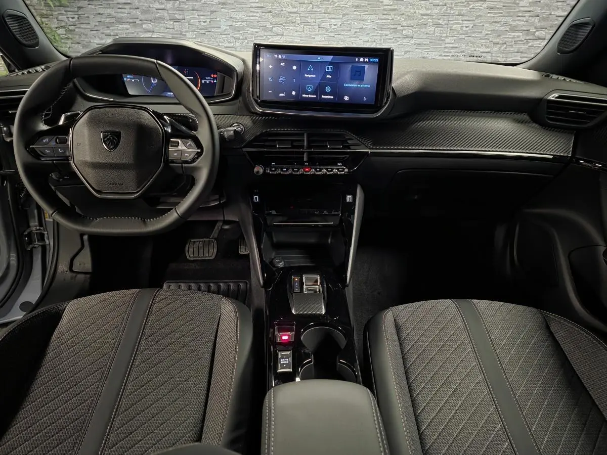 Vue intérieure avant du Peugeot 2008 gris 2025, avec tableau de bord numérique et écran tactile central.