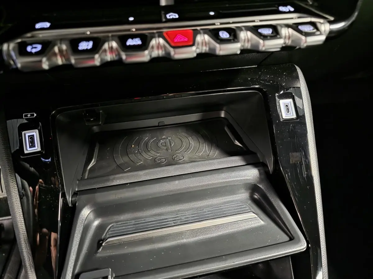 Détail de la console centrale noire du Peugeot 2008 2025 avec plateau de recharge sans fil et ports USB type C.