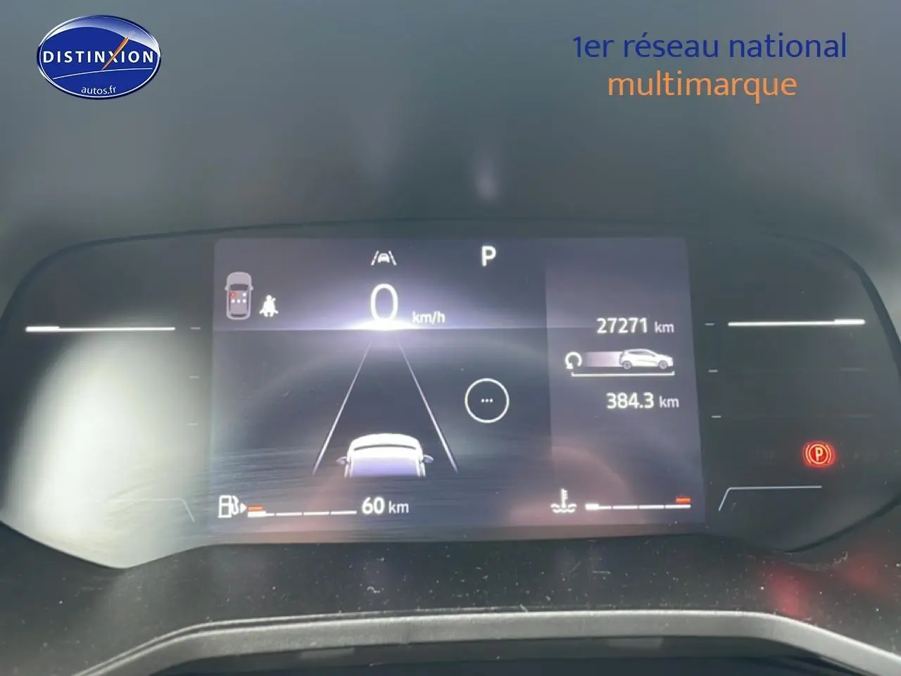 Affichage numérique du tableau de bord de la Renault Clio V blanche, montrant la vitesse à 0 km/h et l'autonomie restante.