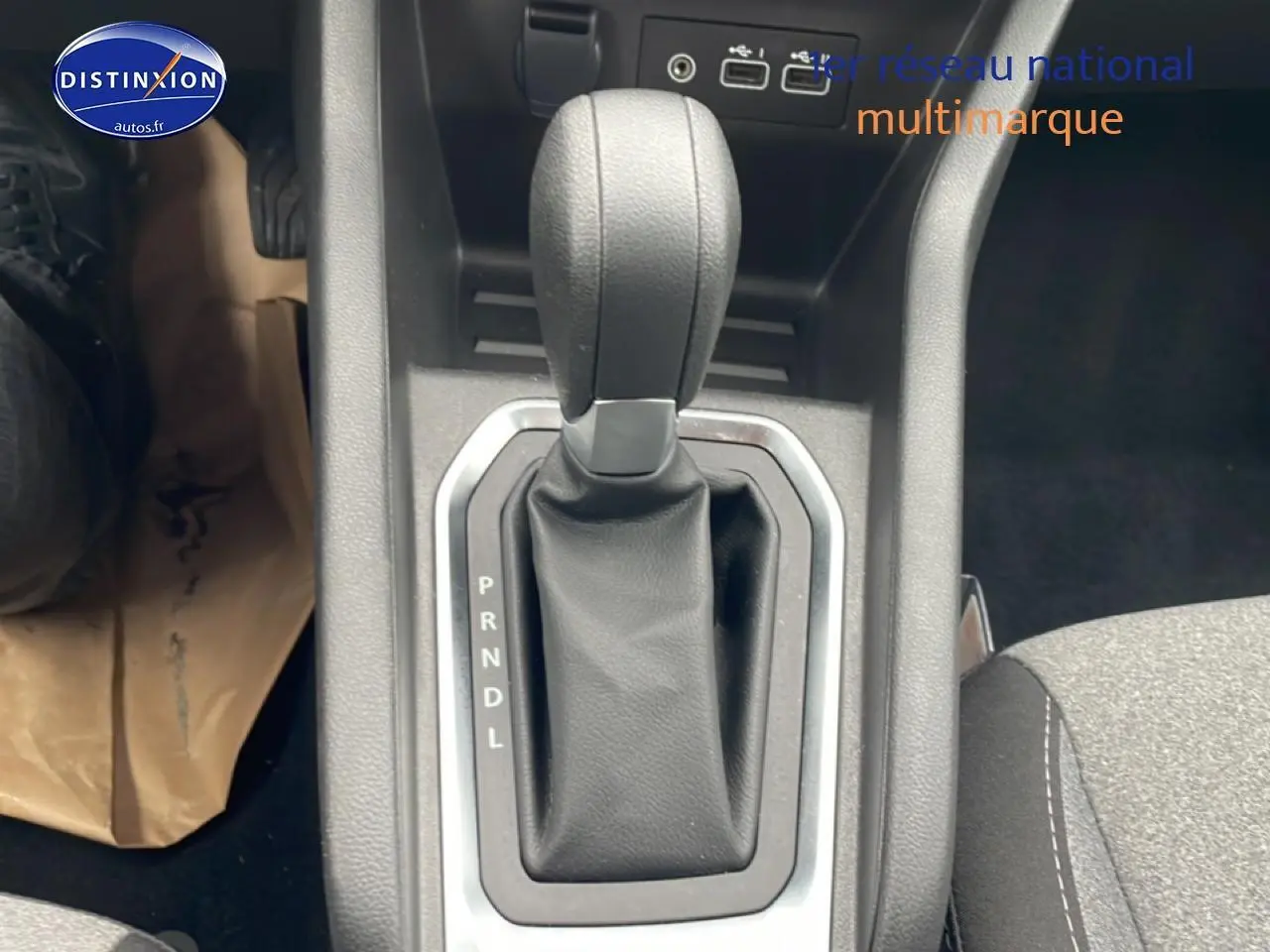 Le levier de boîte automatique noir de la Renault Clio V 1.0 TCe 90 vue en gros plan depuis l'intérieur côté conducteur.