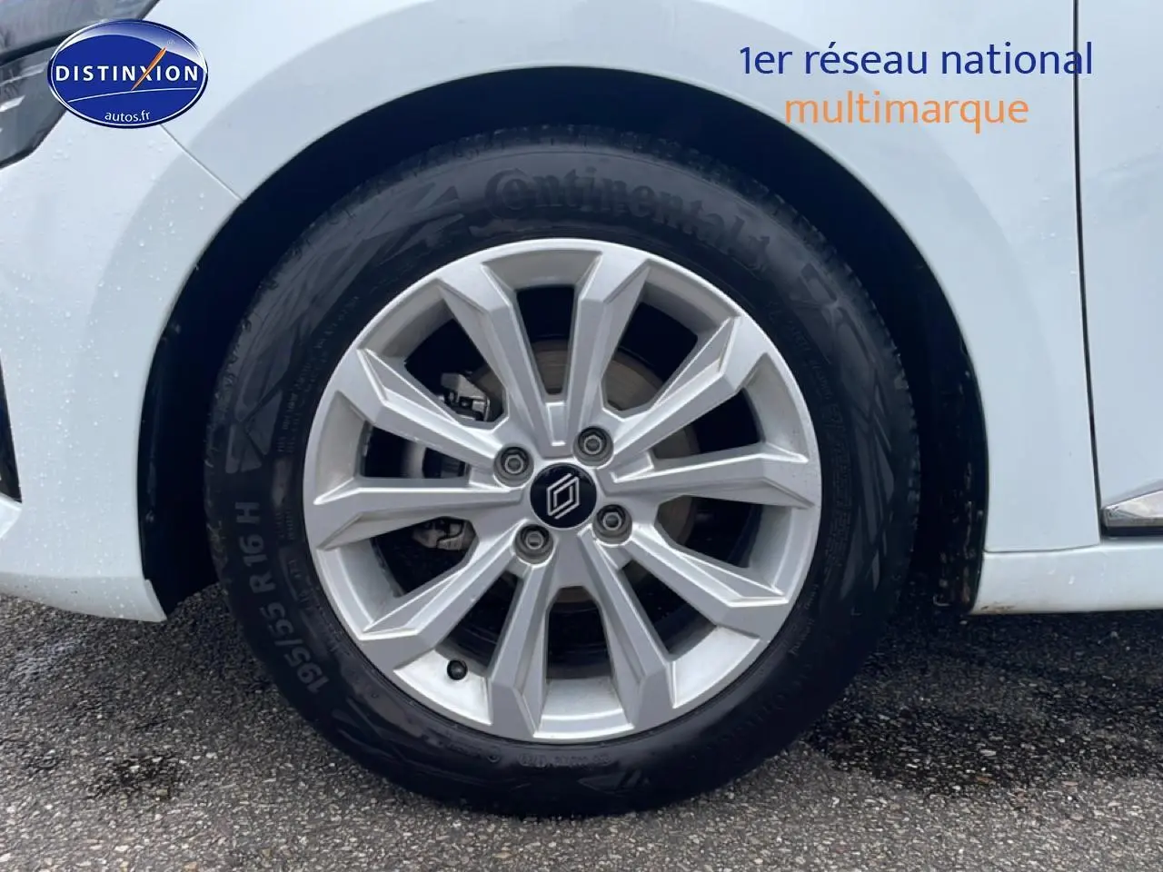 Gros plan sur la roue avant droite d'une Renault Clio V blanche avec jante alliage 16 pouces.