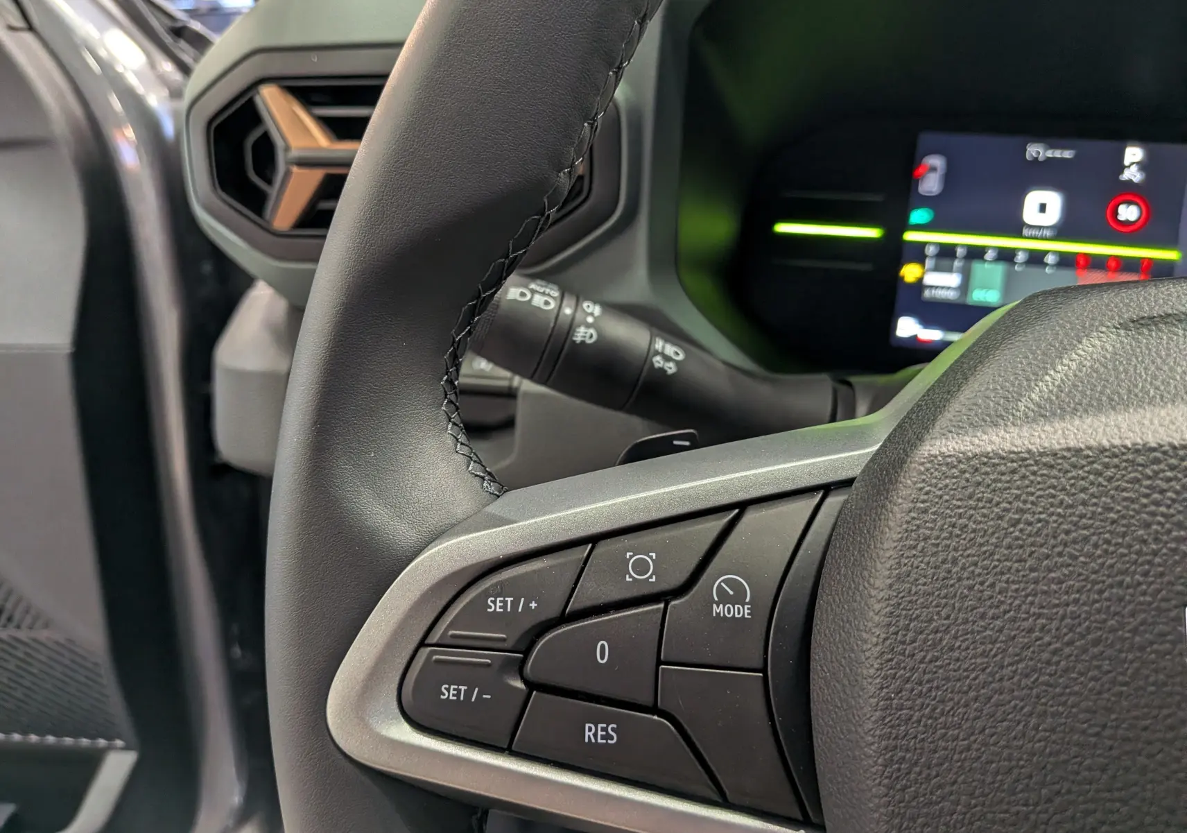 Gros plan sur le volant et commandes du DACIA Duster gris schiste, avec tableau de bord numérique en arrière-plan.