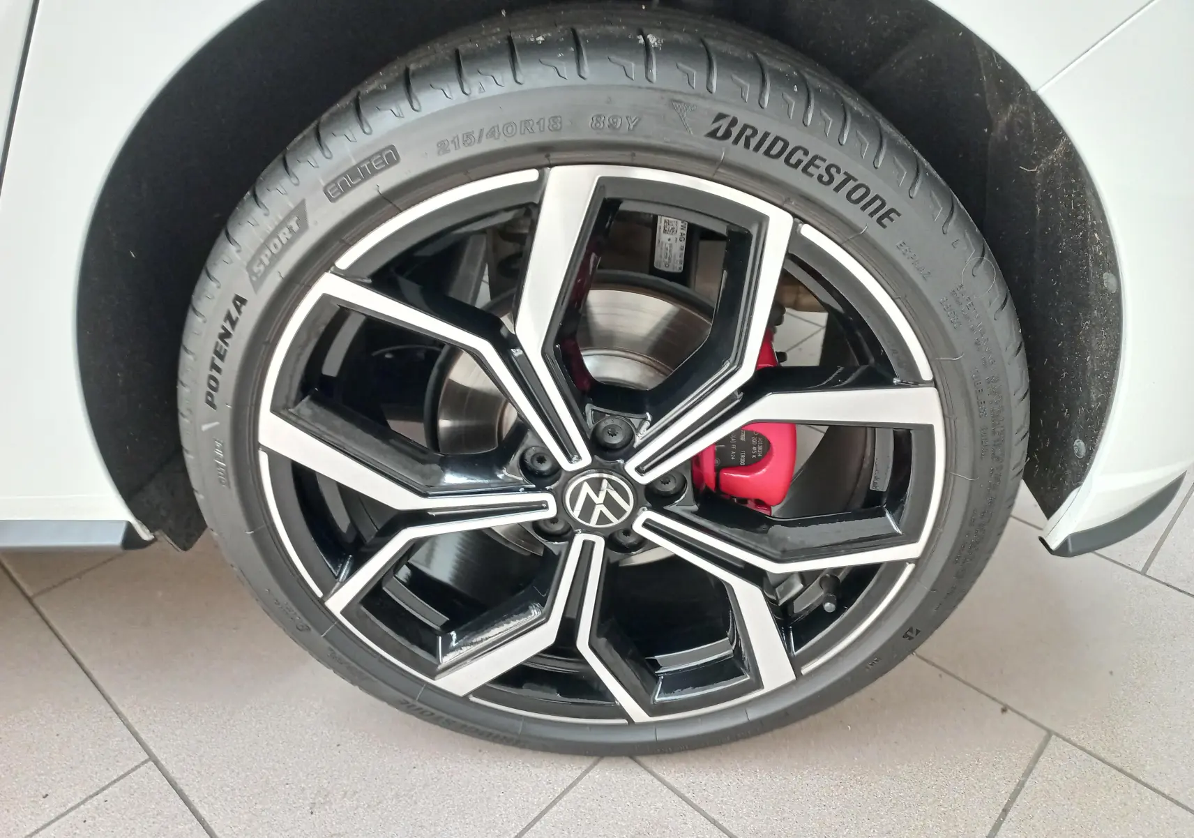 Gros plan sur la jante alliage 18'' noire et argentée de la Volkswagen Polo GTI blanche avec étrier de frein rouge visible.