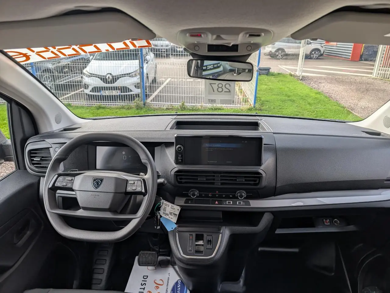 Vue intérieure avant du Peugeot Expert Fourgon noir 2025, tableau de bord moderne avec écran tactile central et volant multifonction.