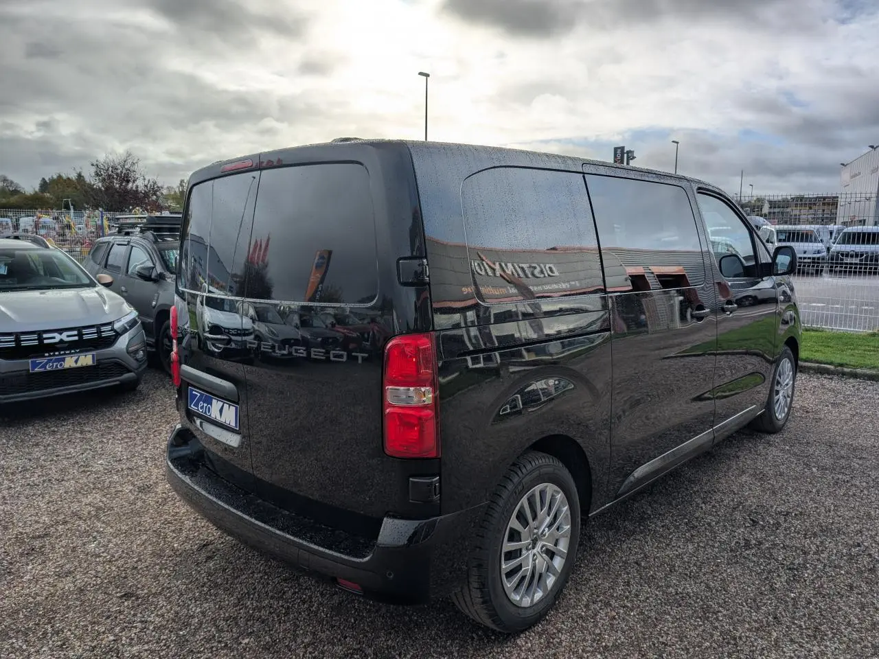 Vue 3/4 arrière droite d'un Peugeot Expert Fourgon noir brillant avec vitres teintées et jantes alliage.