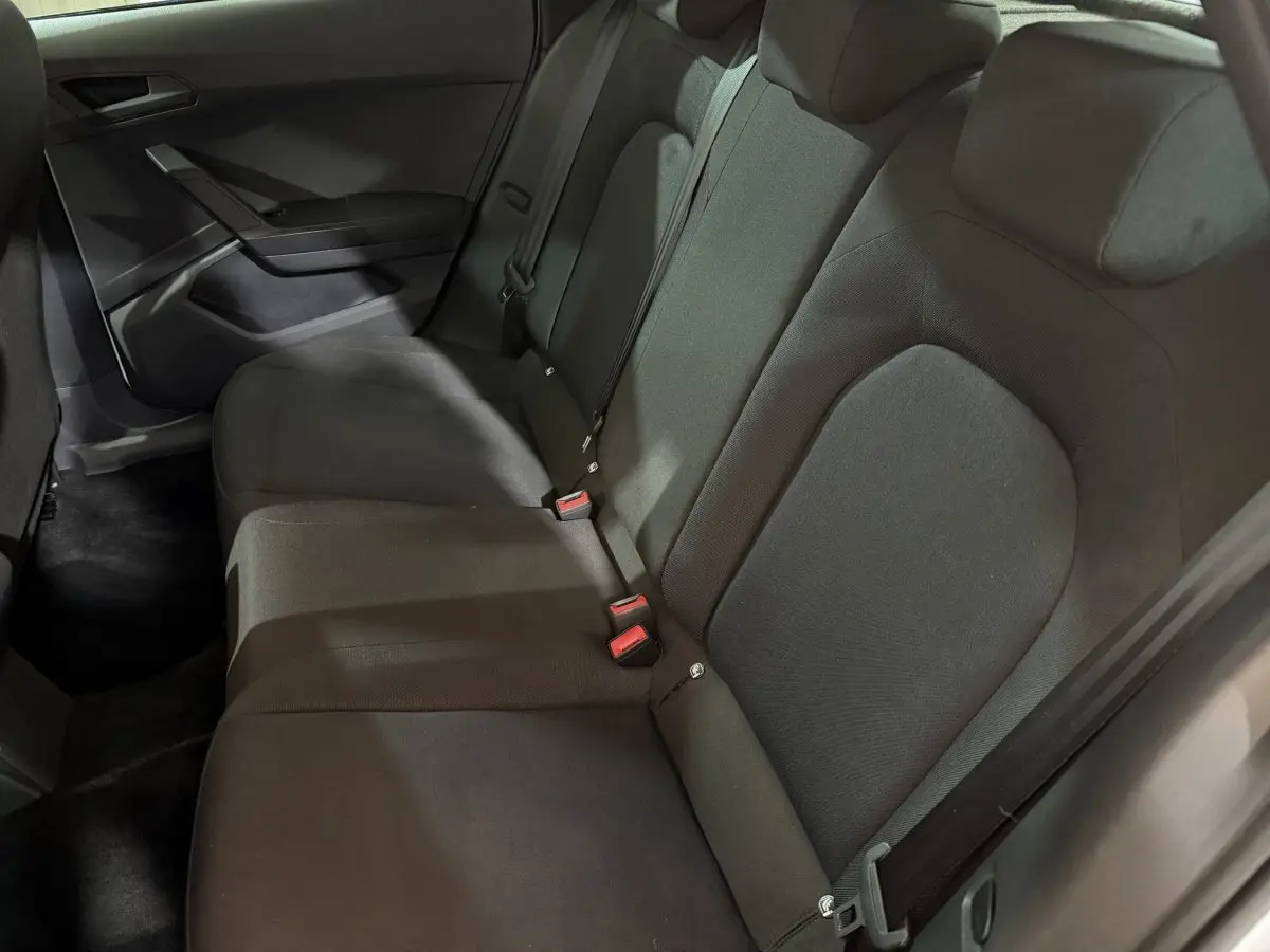Vue intérieure de la banquette arrière noire de la SEAT Ibiza 2024, côté droit, avec ceintures et appuie-têtes visibles.