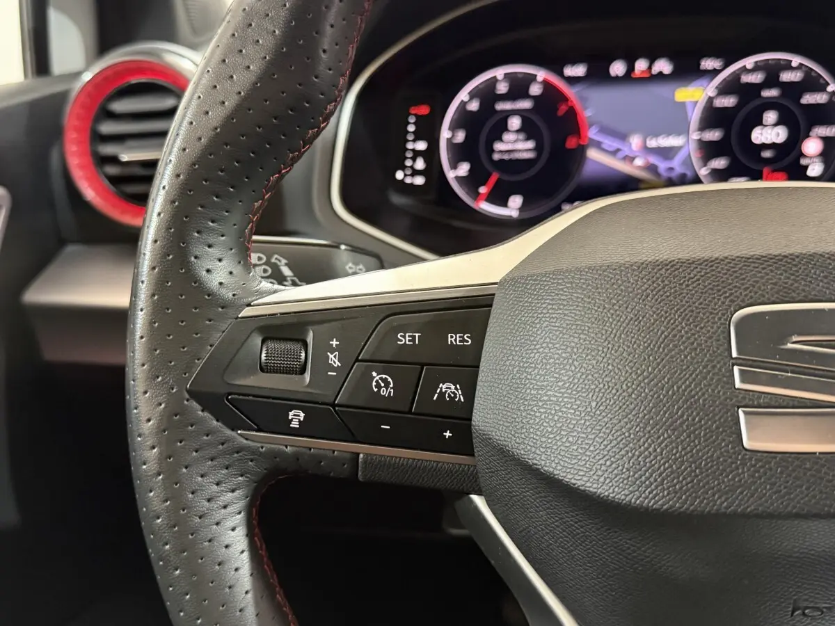 Gros plan sur le volant cuir et alu de la SEAT Ibiza 1.0 TSI 110 FR 2024 avec commandes multifonctions et tableau de bord numérique.