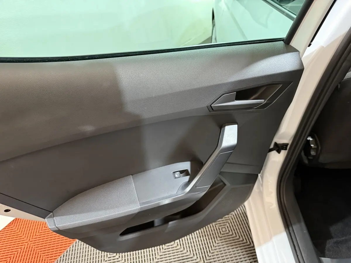 Vue intérieure de la porte arrière droite blanche d'une SEAT Ibiza 2024 avec panneau noir et poignée angulaire.