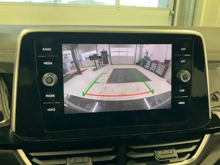 Vue intérieure de l'écran tactile du Volkswagen T-Roc 2025 noir intense affichant la caméra de recul avec lignes de guidage colorées.