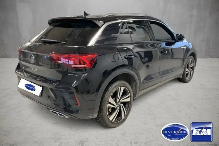Vue 3/4 arrière droit d'un Volkswagen T-Roc noir intense 2025, avec jantes bi-ton et feux arrière LED distinctifs.