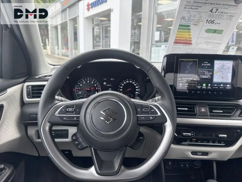 Vue intérieure centrée sur le volant cuir multifonction d'une Suzuki Swift 1.2 Hybrid 2025 avec tableau de bord et écran tactile.