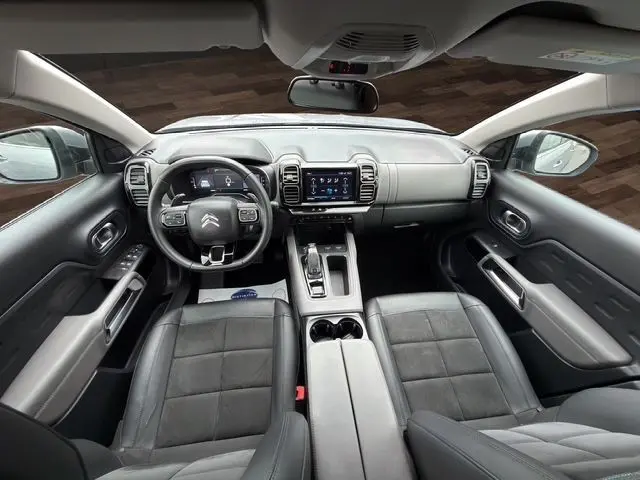 Vue intérieure avant du Citroën C5 Aircross gris acier 2022, avec tableau de bord numérique et sièges en tissu noir.