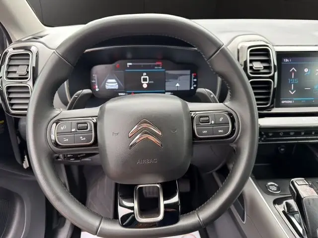 Vue rapprochée du volant noir du Citroën C5 Aircross 2022 avec tableau de bord numérique et écran tactile central.