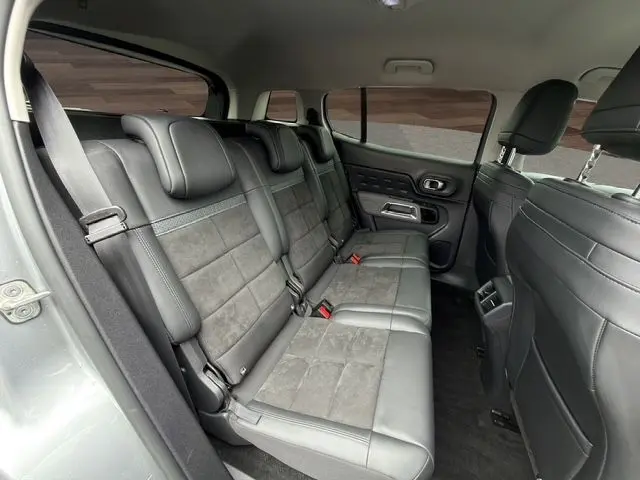 Vue intérieure côté gauche montrant la banquette arrière en cuir et tissu gris du Citroën C5 Aircross 2022.