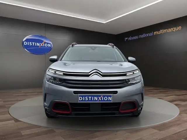Vue avant centrée du Citroën C5 Aircross gris acier avec détails rouges sur le pare-chocs et calandre distinctive.