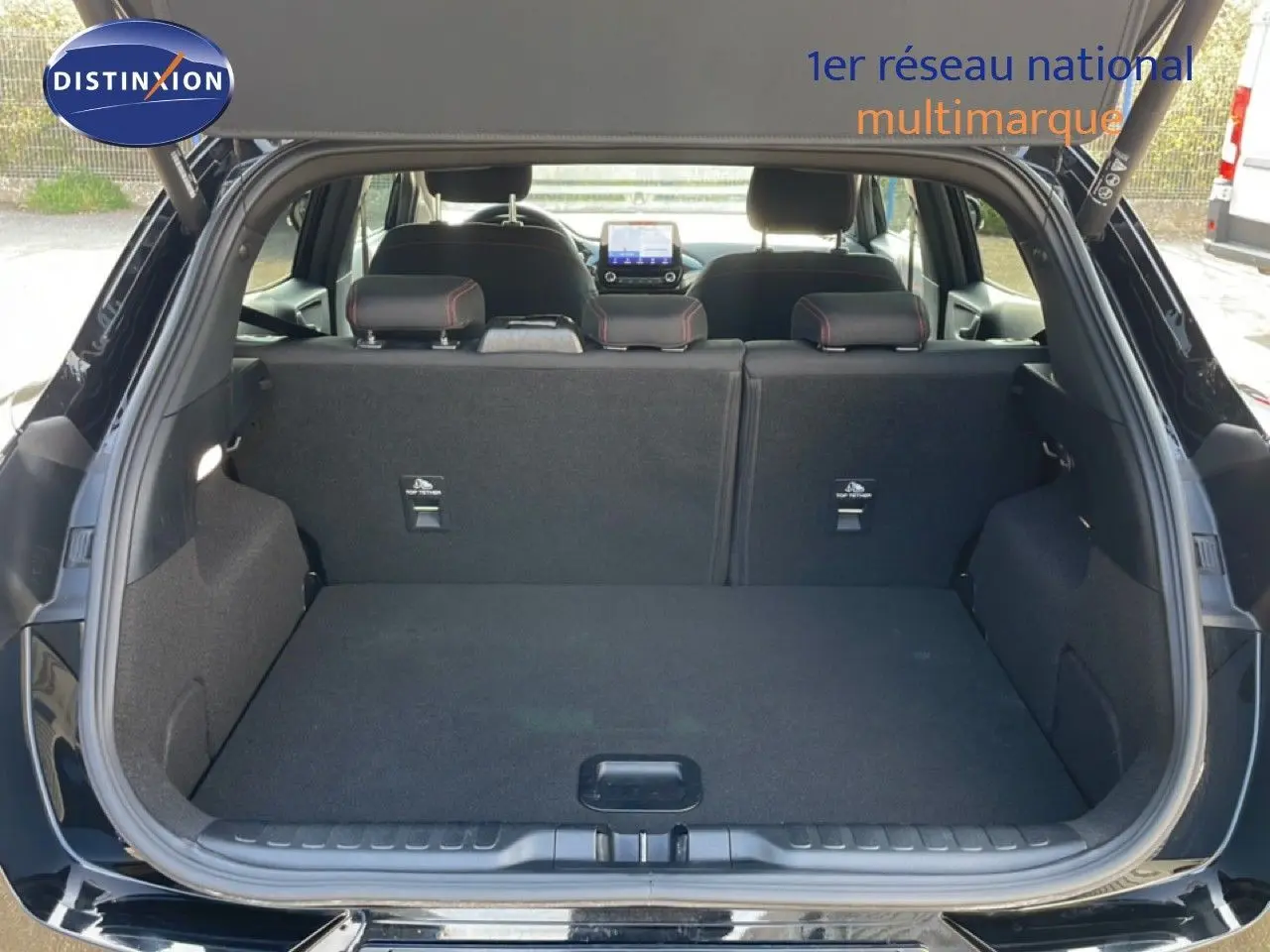 Coffre ouvert vu de l'arrière d'un Ford Puma noir Agate Métal, montrant l'espace de chargement et les sièges arrière.