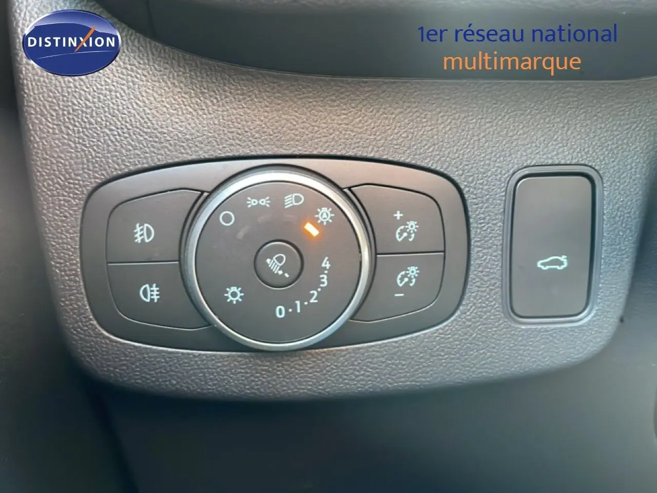 Gros plan sur le panneau de commandes d’éclairage et ouverture du coffre du Ford Puma noir Agate 2023, intérieur noir texturé.