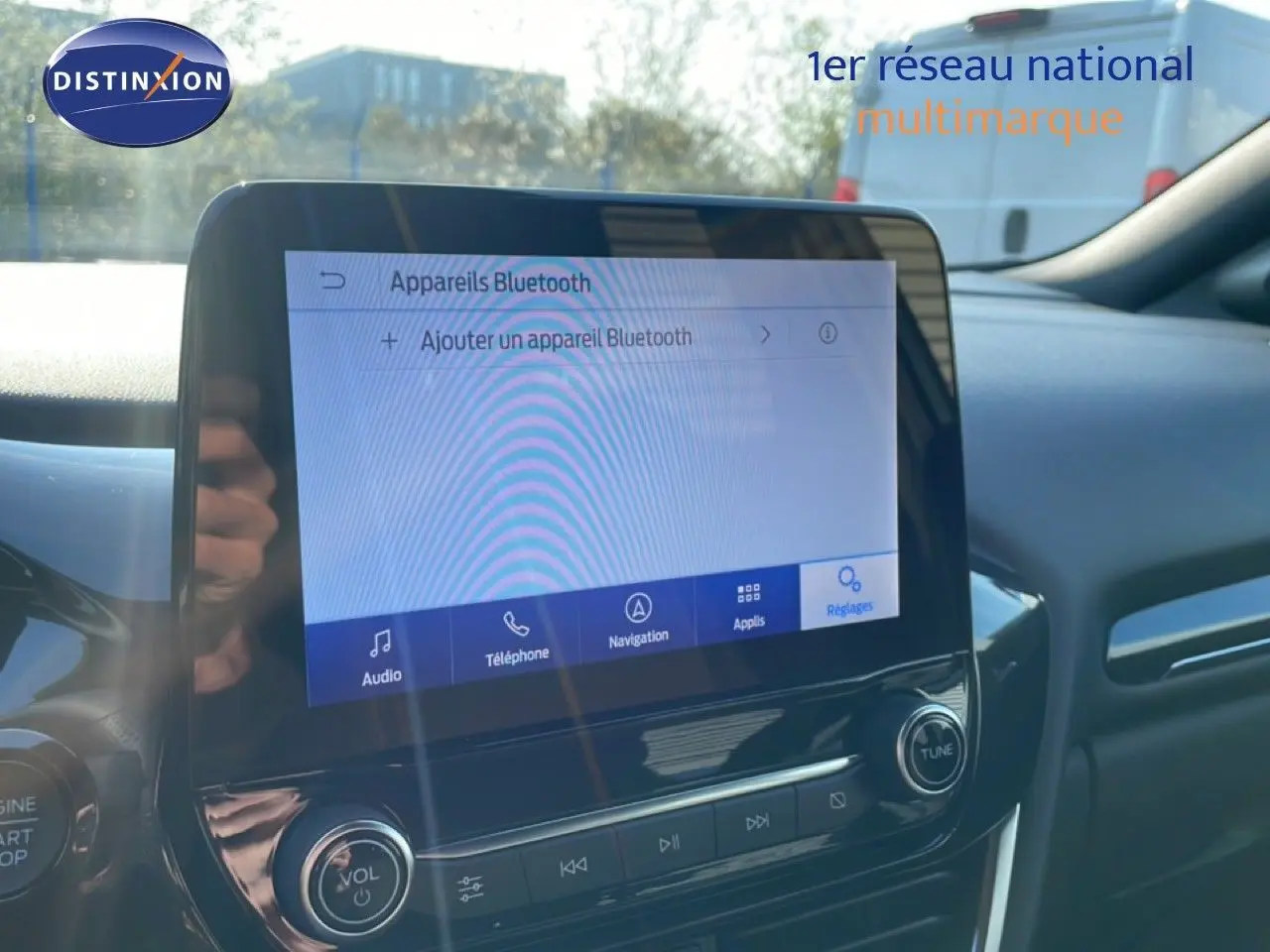 Vue intérieure du tableau de bord du Ford Puma 2023, écran tactile affichant les réglages Bluetooth, ambiance moderne noire.