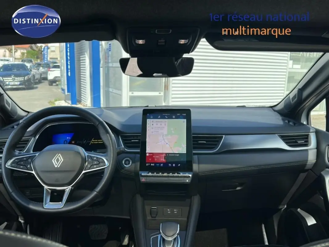 Vue intérieure avant du Renault Symbioz blanc 2025, mettant en valeur le tableau de bord moderne avec écran tactile vertical.