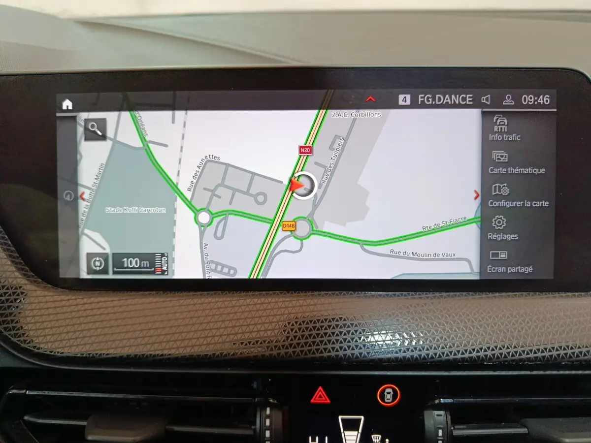 Écran tactile central affichant la navigation GPS dans l’habitacle d’une BMW Série 1 noire, vue intérieure frontale.