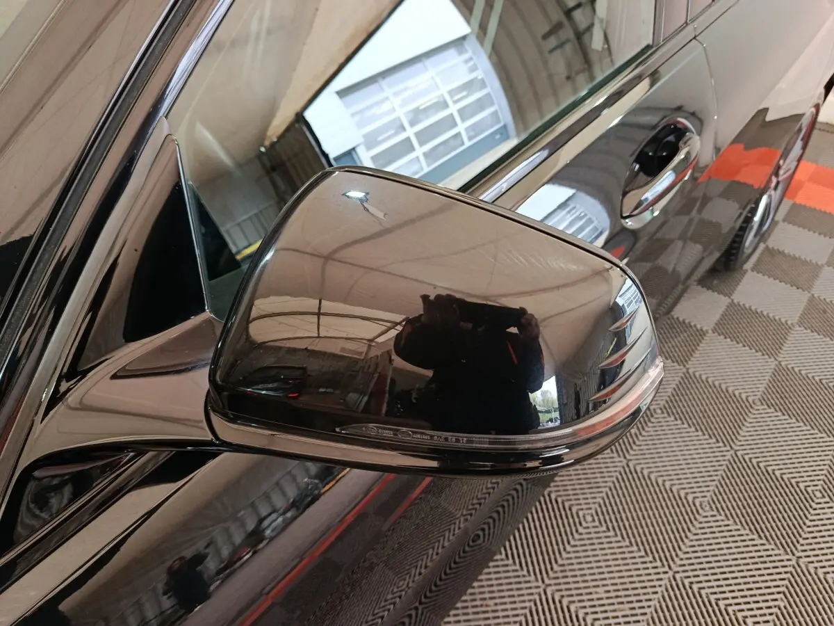 Rétroviseur côté gauche noir brillant d’une BMW Série 1 118i Edition Sport 2023, vue rapprochée en intérieur.