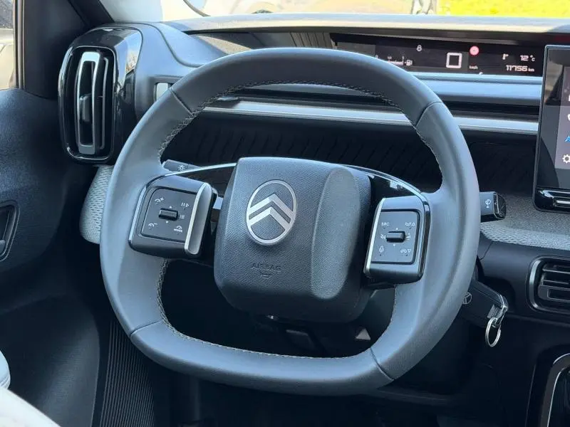 Vue rapprochée du volant de la Citroën C3 1.2 Turbo 100ch MAX 2025, avec commandes intégrées et tableau de bord numérique.