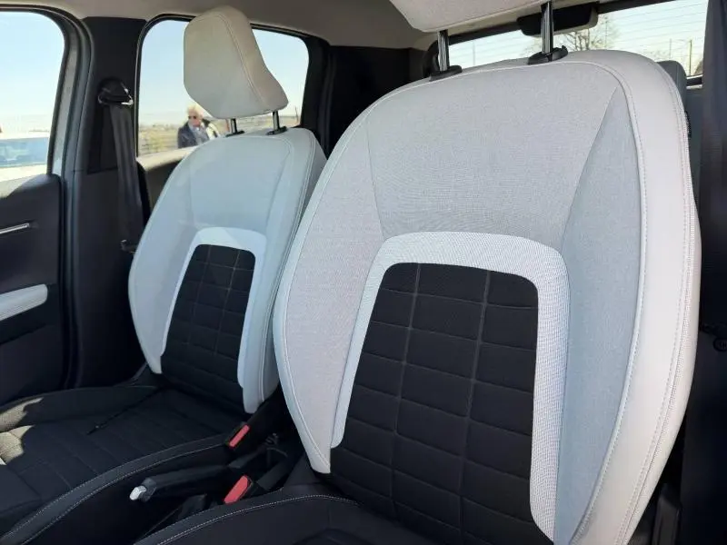 Gros plan sur les sièges avant bicolores gris clair et noir de la Citroën C3 1.2 Turbo 100ch MAX 2025, intérieur lumineux.