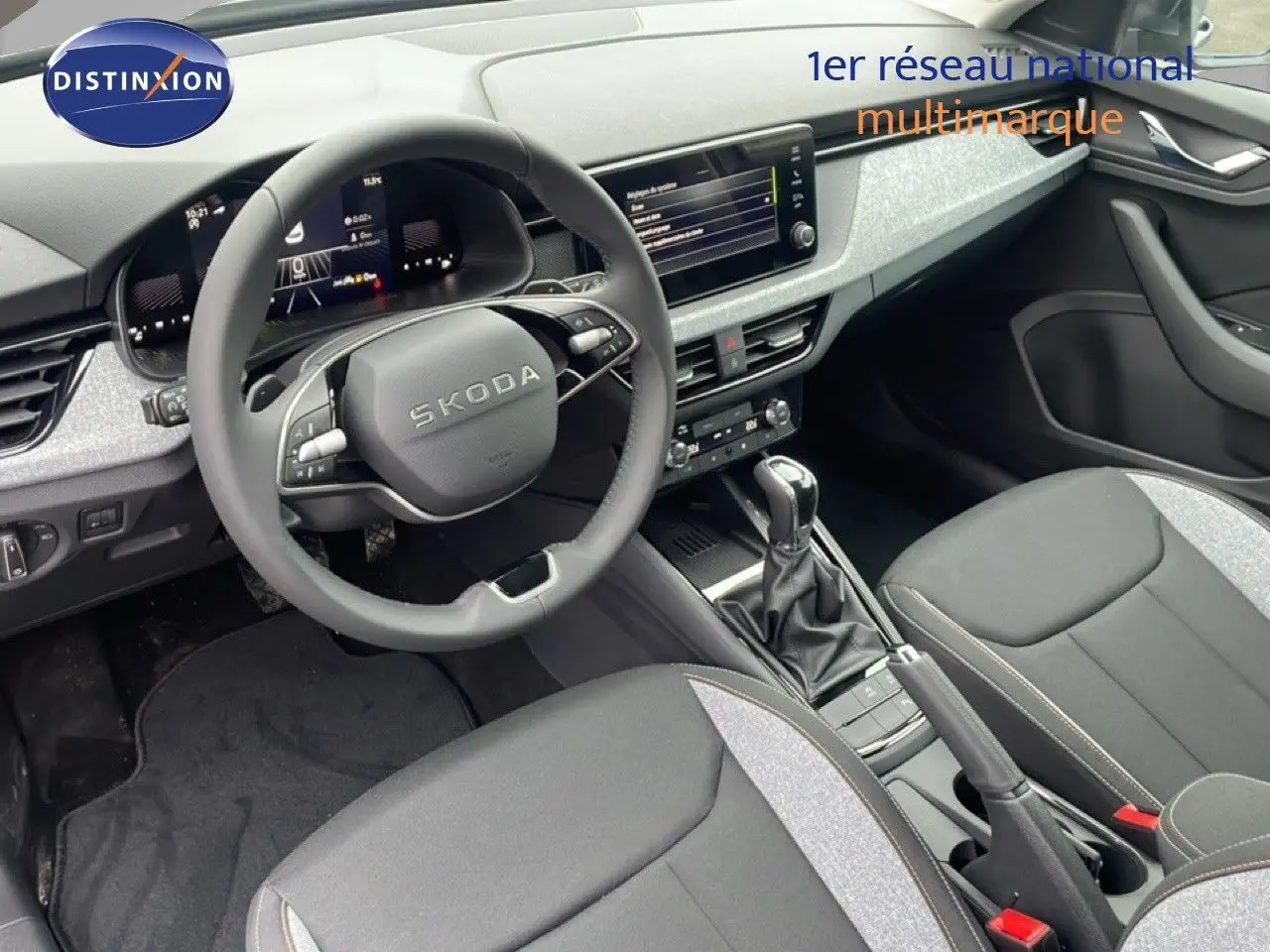 Intérieur du Skoda Kamiq 2025 vu côté conducteur, avec volant multifonction et sellerie tissu gris noir.