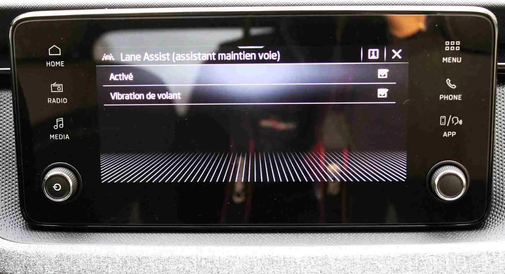 Écran tactile central du Skoda Kamiq 2025 affichant les réglages de l'assistant maintien de voie et vibration de volant.