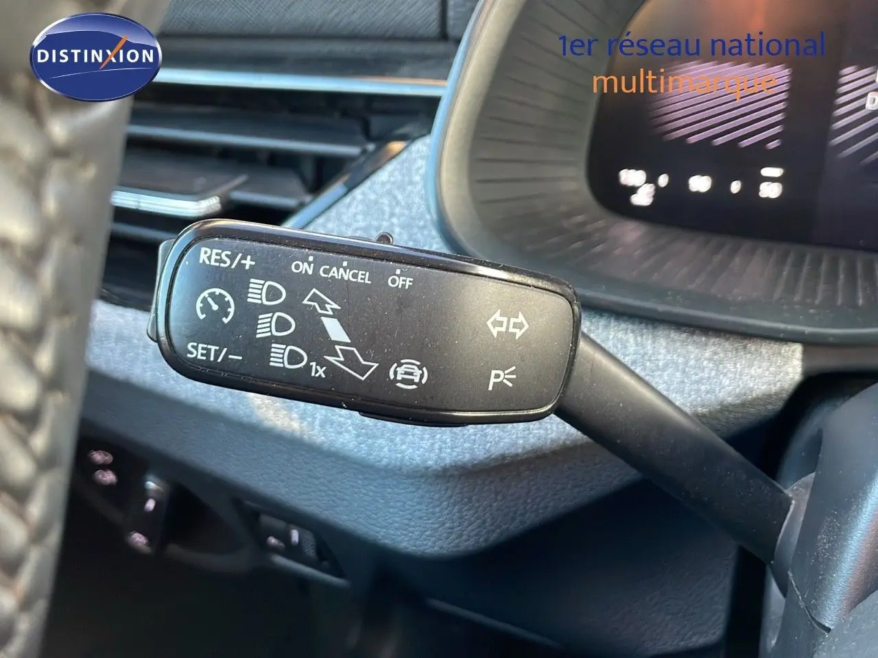 Gros plan sur le commodo gauche du tableau de bord d’un Skoda Kamiq 2024 gris graphite, montrant les commandes de régulateur et feux.