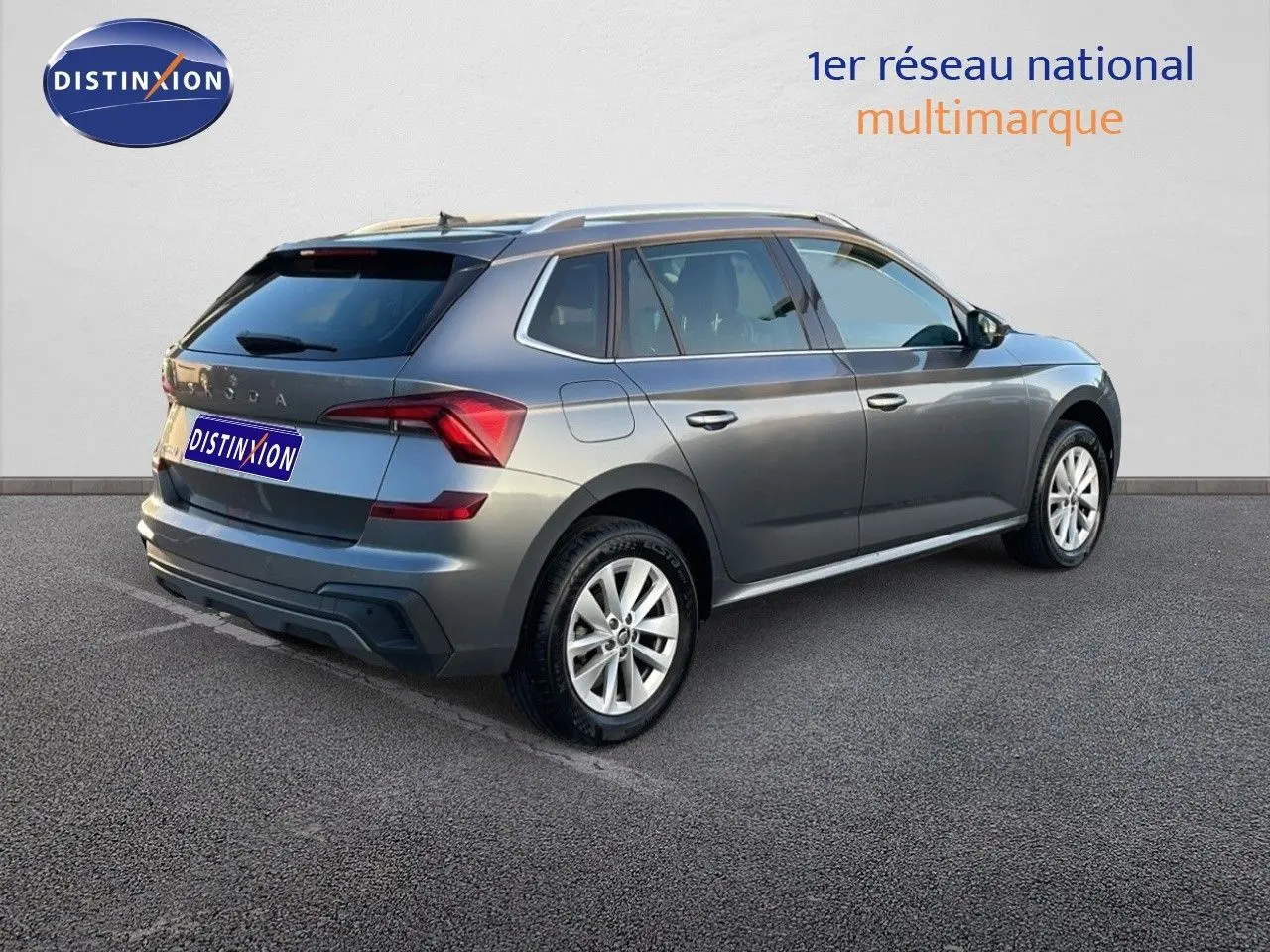 Vue 3/4 arrière droite d’un Skoda Kamiq gris graphite métal 2024 avec jantes alliage et toit ouvrant.